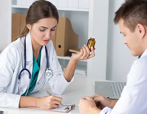SMWC - Female medicine doctor prescribing pills to her male patient