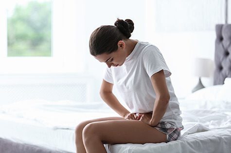 SMWC - woman suffering from menstrual cramps