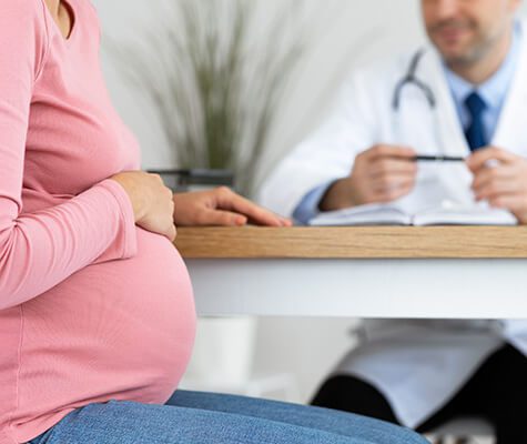 SMWC - Prenatal Care Concept. Unrecognizable pregnant woman having consultation with a male doctor