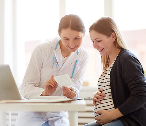 SMWC - smiling female obstetrician consulting pregnant woman